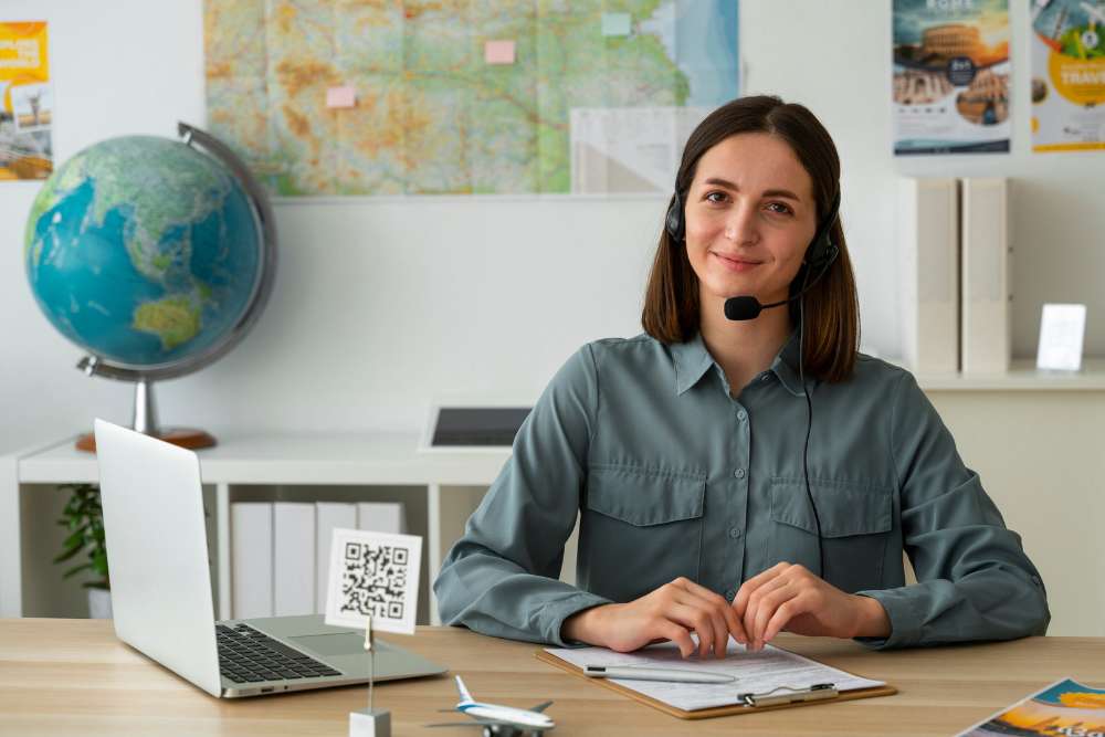 Professional woman wearing a headset working at a desk with a laptop and documents — representing logistics virtual assistant services for freight and supply chain support.